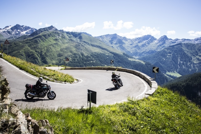 Zwei Motorradfahrer genießen Ihre Fahrt über einen Bergpass im Tiroler Oberland