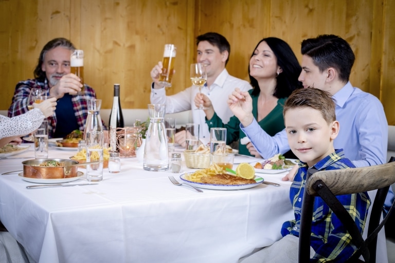 Eine Familie genießt ein gemeinsames Abendessen im Landecker Restaurant "Das Landegger" im Hotel Schrofenstein.