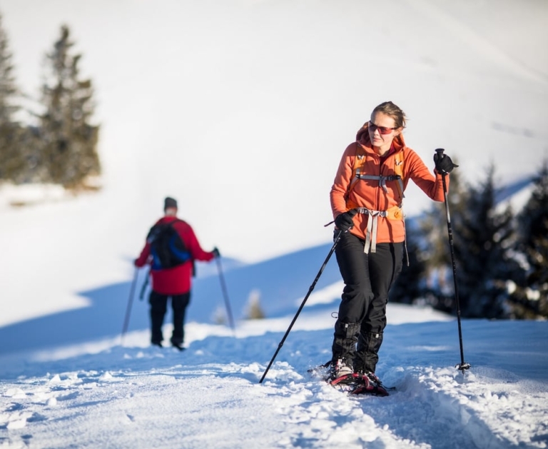 Frau beim Schneeschuhwandern im Tiroler Oberland inmitten einer verschneiten Landschaft