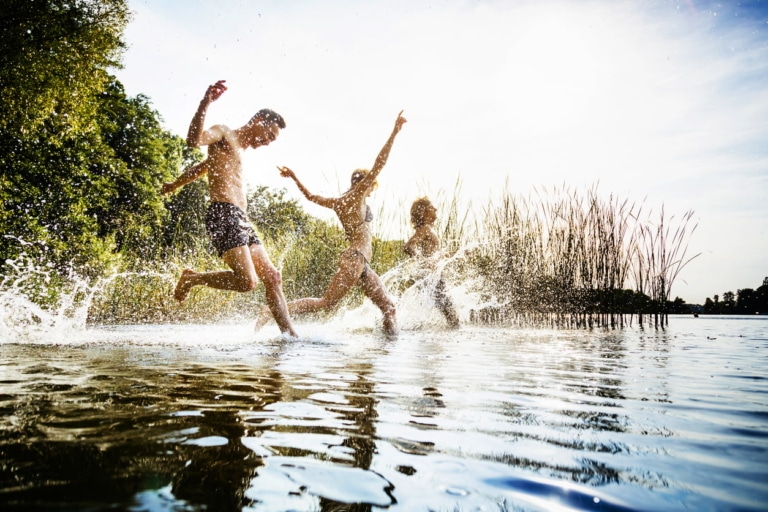 3 Personen laufen ins Wasser